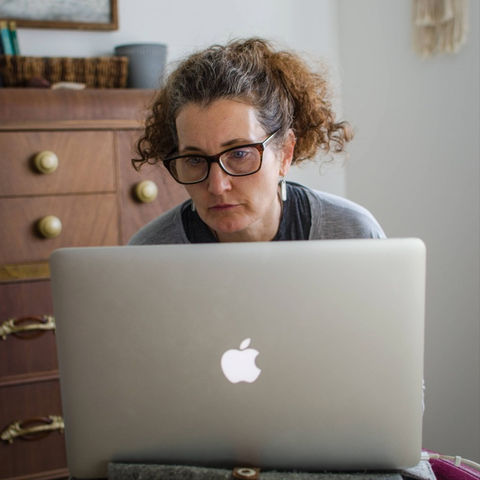 Patricia Neumann behind her laptop writing